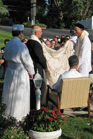 Ara Antar: couple face one another<br>as a sheet is hung between them