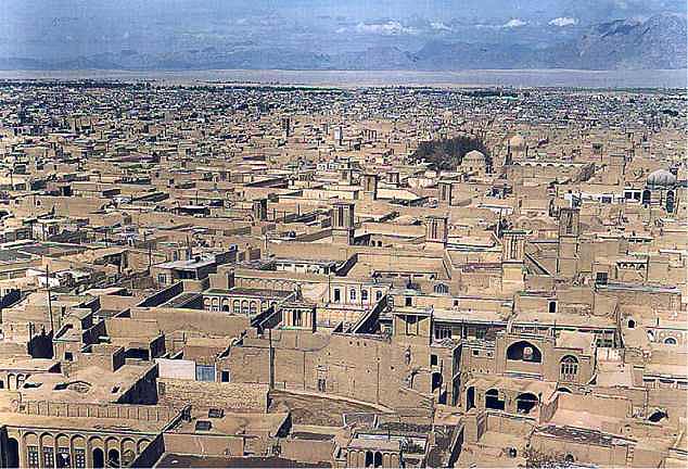 Sand coloured Yazd skyline with mountains in the background